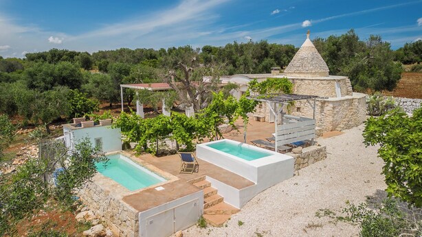 A villa with a swimming pool, outdoor seating, and a stone structure. - Trullo Solleone by Perle di Puglia (Carovigno)