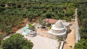 An olive grove with a stone building, a swimming pool, and a garden. - Trullo Solleone by Perle di Puglia (Carovigno)