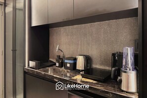 A modern kitchen with stainless steel appliances, a built-in sink, and a countertop. - Hit Cabo Branco III - LikeHome (João Pessoa)