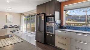 A modern kitchen with a built-in oven, microwave, and refrigerator. - The Blue Window - 15 Mins to CBD&Airport (Howrah)