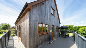A wooden building with a deck, a door, and a window.