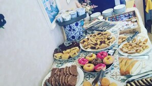 Noutopöytä, jossa on tarjolla monenlaista ruokaa, kuten leivoksia, piirakoita ja donitseja.