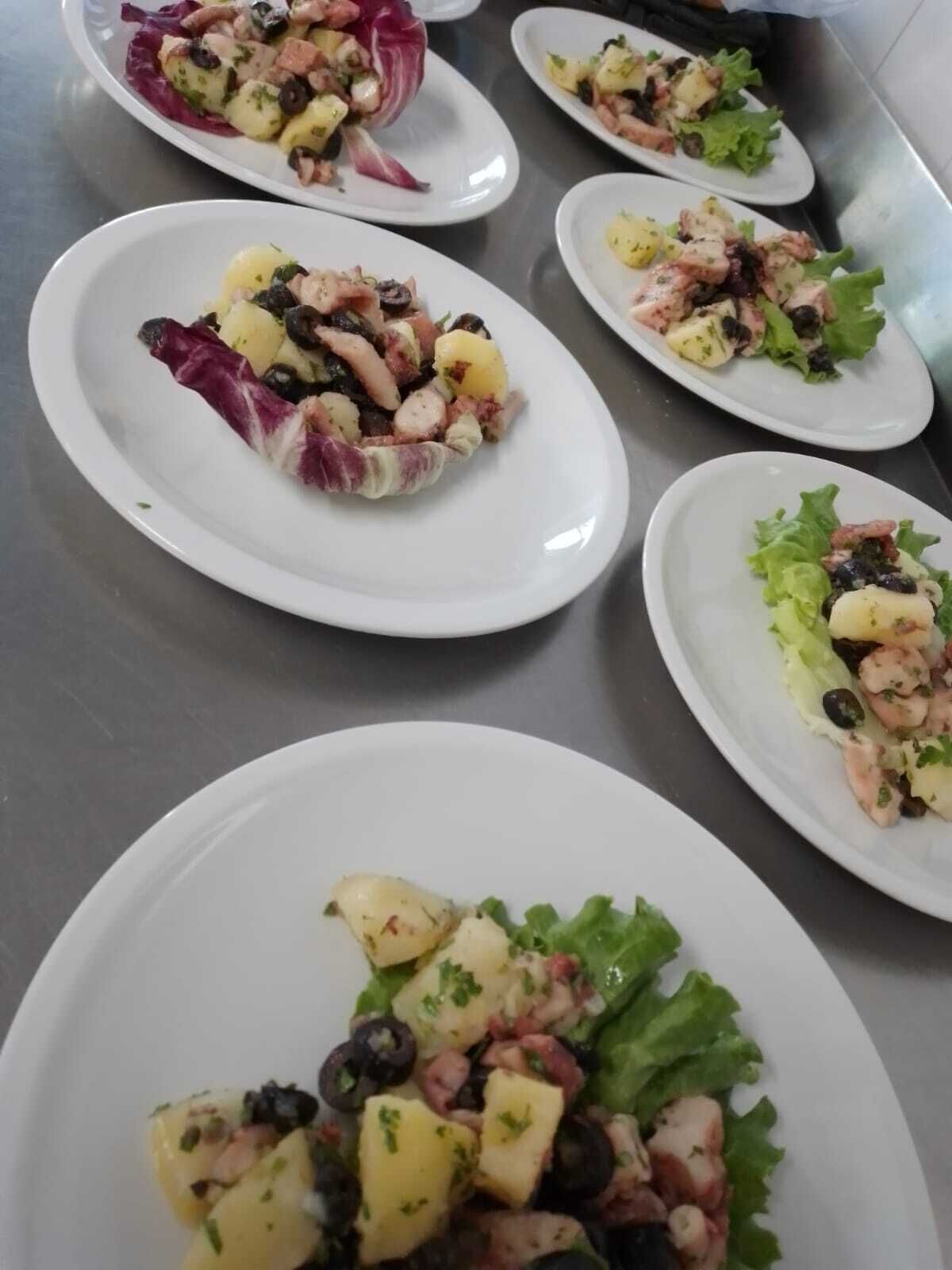 A series of white plates with salads containing various ingredients.