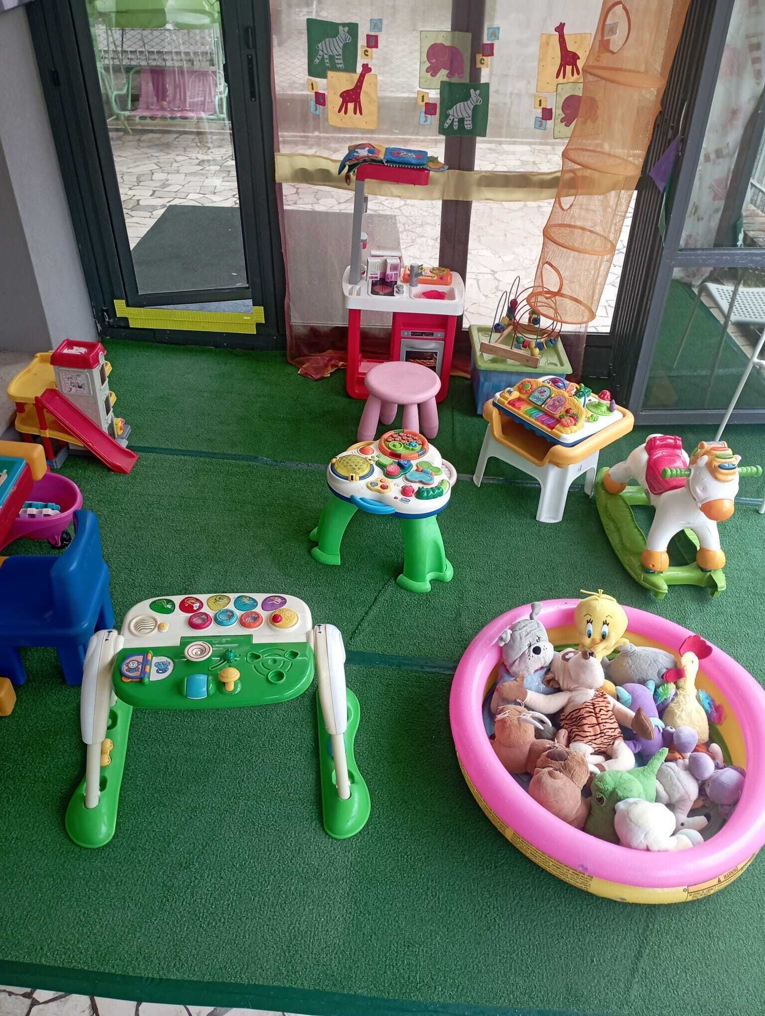 Un espace de jeux pour enfants avec différents jouets et équipements de jeu.