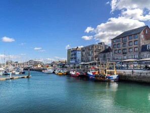 A harbor with boats docked, a stone building, and a clear sky. - 2 bed house near Devonport Dockyard Plymouth (Plymouth)
