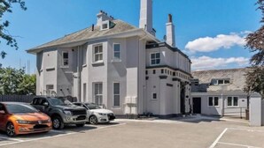 A two-story building with a parking lot in front. - Modern 2 bed Plymouth apartment with city views (Plymouth)
