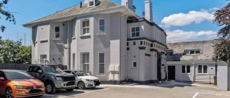 A two-story building with a parking lot in front.
