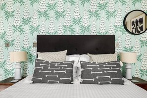 A bed with a dark headboard, two bedside lamps, and patterned pillows. - Sancroft by Pureserviced (Plymouth)