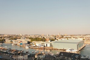 A harbor with boats, a large industrial building, and residential buildings in the background. - 2 Bed - Leeward House by Pureserviced (Plymouth)