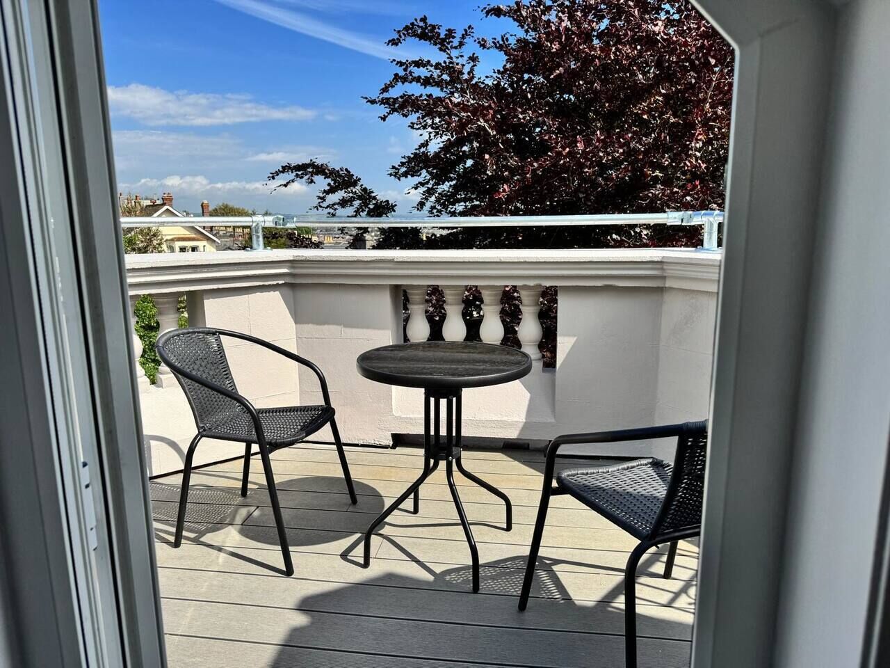 Une terrasse extérieure avec une table ronde et deux chaises.