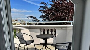 Un patio al aire libre con una mesa redonda y dos sillas.
