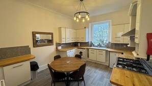 Una cocina moderna con una mesa de comedor, electrodomésticos integrados y un ventanal que proporciona luz natural.