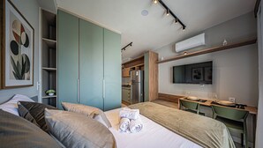 Une chambre d’hôtel moderne équipée d’un lit, d’un bureau et d’une kitchenette.