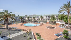 A resort with a swimming pool, palm trees, and lounge chairs. - Vacation Apartment 'Popcorn Beach House' with Shared Pool, Balcony and Wi-Fi (Corralejo)