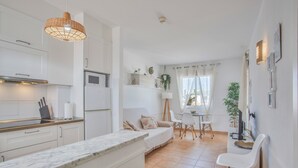 A modern kitchen with white cabinets, a marble countertop, and a hanging light fixture. - Vacation Apartment 'Popcorn Beach House' with Shared Pool, Balcony and Wi-Fi (Corralejo)