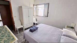 A bedroom with a bed, a wardrobe, a chair, and a small table. - Villetta Murena - Con Piscina Privata E Vista Mare (Corsano)