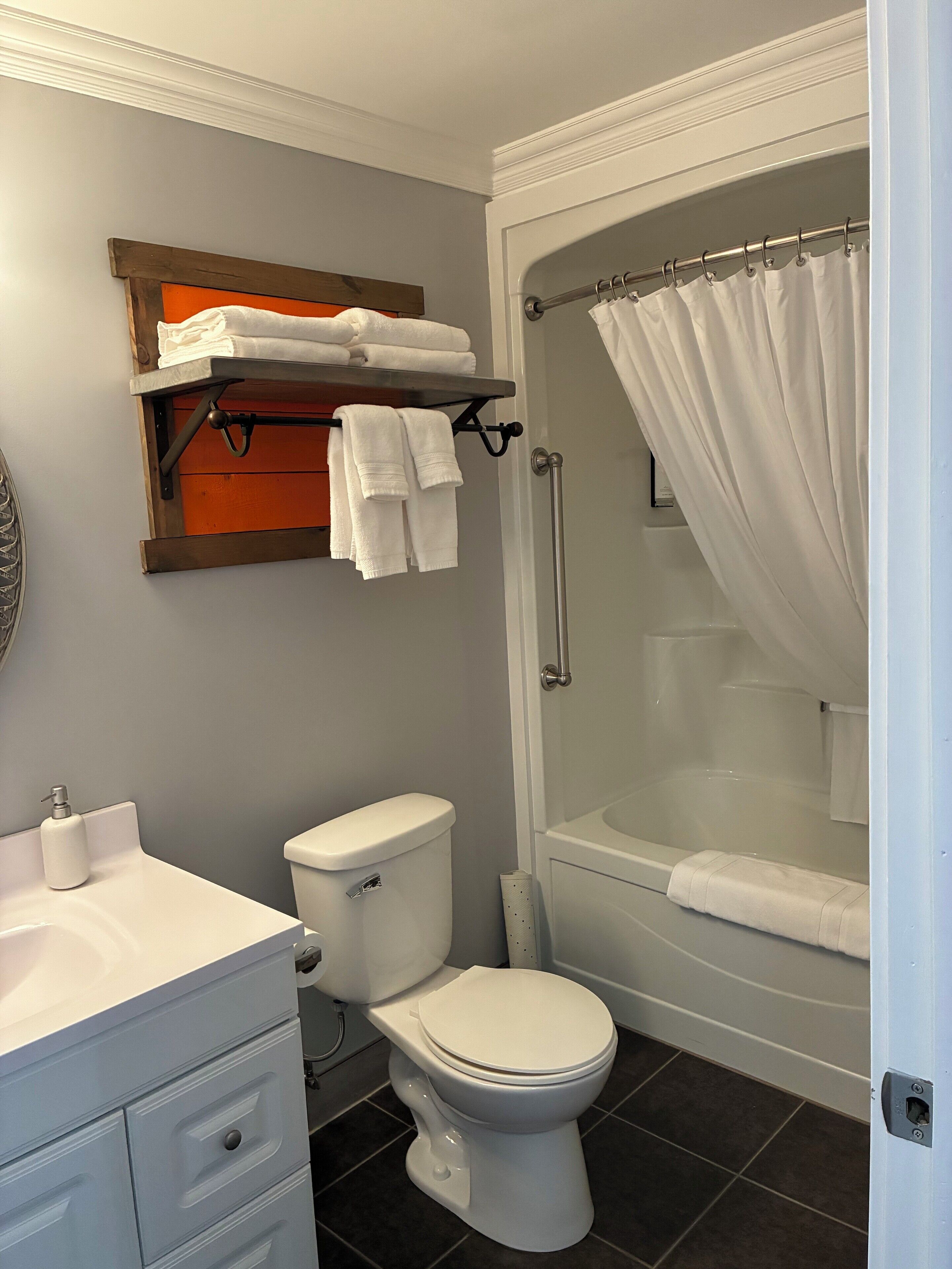 Een badkamer met toilet, wastafel en douche.