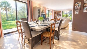 A dining area with a large table, chairs, and a view of the outdoors.