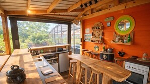 A rustic kitchen with wooden countertops, a stove, and bar stools.