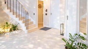 A spacious interior with a staircase, a potted plant, and a door.