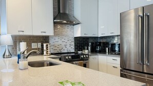 Eine moderne Küche mit Edelstahlgeräten, einer Granit Arbeitsplatte und weißen Schränken.
