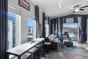 Ein modernes Wohnzimmer mit Essbereich, großen Fenstern und Seeblick.