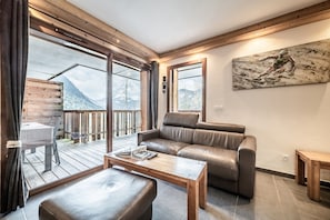 Ein modernes Wohnzimmer mit Ledersofa, Couchtisch aus Holz und einem Gemälde an der Wand.