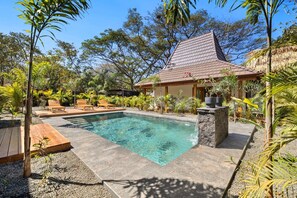 A swimming pool with a tiled deck, surrounded by lounge chairs and tropical plants. - Boutique Villa 5 Suites with Private Pool in Playa Avellanas. 5 min from the sea (Guanacaste Province)
