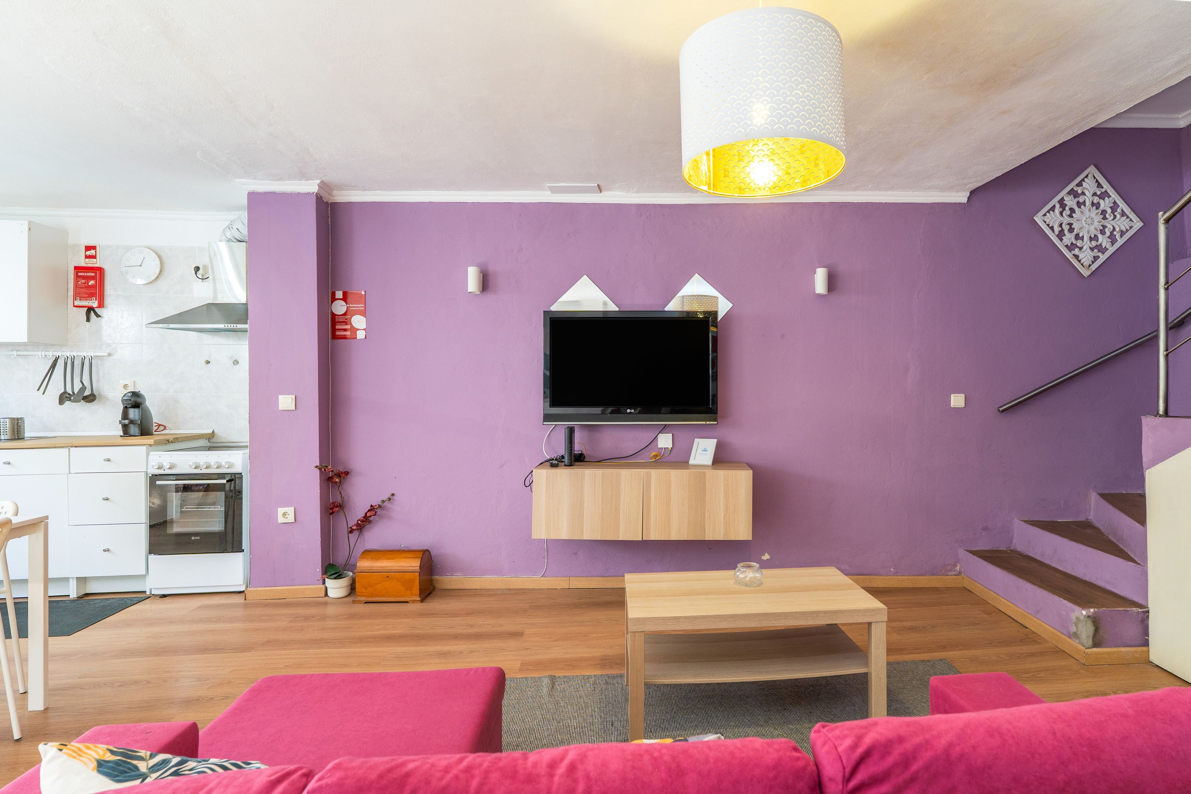 Un salon moderne avec un téléviseur à écran plat, une table basse en bois et un canapé.