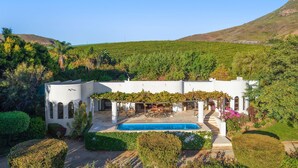A white villa with a swimming pool, surrounded by lush greenery and hills. - Riebeek-Kasteel Villa (Riebeek-Kasteel)