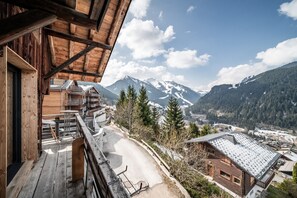 Eine Holzhütte mit Balkon mit Blick auf eine Berglandschaft.