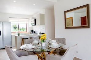 A modern kitchen with a dining area. - 2-Bedroom Apartment with Pool and Garden View (Punta Cana)