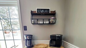 Een keukenhoek met een koffiehoekje, een rieten mand en een Keurig koffiezetapparaat.