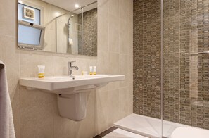 Ein Badezimmer mit Waschbecken, Spiegel und Dusche.