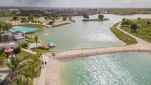 Luchtbeeld van een resort met een zwembad, een steiger en een strandgebied.