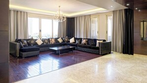 Ein geräumiges Wohnzimmer mit einem Ecksofa, einem Couchtisch und einer Chandelier.