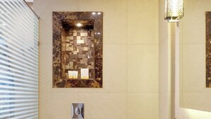 Ein modernes Badezimmer mit Marmorwaschtisch, freistehender Badewanne und wandmontierter Toilette.