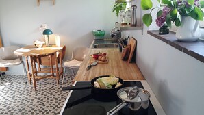 Et lille køkken med komfur, skærebræt og vask.