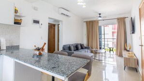 Een moderne keuken met granieten aanrecht, een ingebouwde kookplaat en een eethoek met tafel en stoelen.