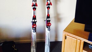 Ein Paar Skier mit Zierelementen, an einer Wand angebracht.