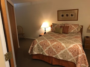 A bedroom with a bed, a nightstand, a chair, and a wall-mounted picture frame. - Fantastic 1-bedroom condo with AC in charming Vail (Vail)