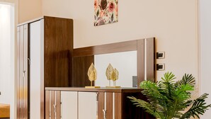 Un armario de madera con puertas de espejo, un cabecero de madera y una planta en maceta.