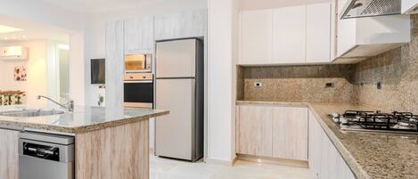 Een koelkast, kookgerei, borden en bestek