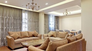 Sala de estar con sofás color beige, una mesa de centro y una araña.