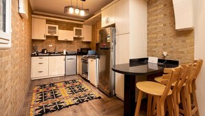 Une cuisine compacte avec des meubles en bois, un four encastré et un réfrigérateur.