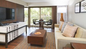 Una sala de estar moderna con una televisión de pantalla plana, una mesa de centro, un sofá y un comedor con sillas y una mesa.