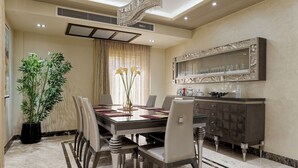 A dining area with a marble table, chairs, a potted plant, and a decorative mirror. - VESTA - Luxury Villa - 6BR - New Cairo (New Cairo City)
