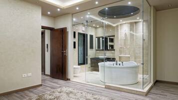 Une salle de bain moderne dotée d’une douche à parois de verre, d’une baignoire sur pieds et d’un meuble-lavabo avec un miroir.