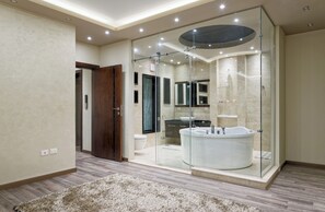 Un baño moderno con ducha de vidrio, una bañera independiente y un tocador con espejo.