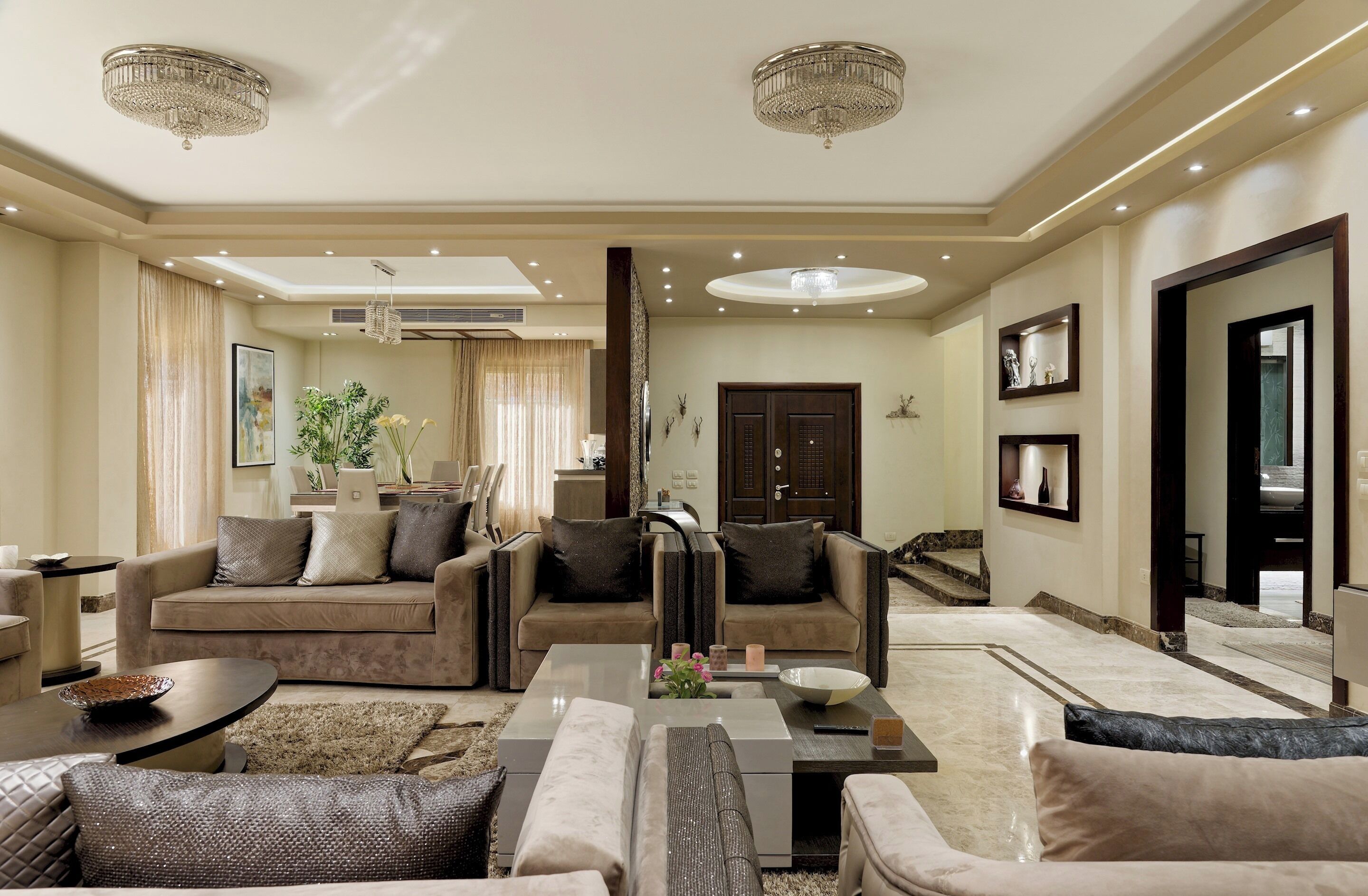 A spacious living room with a sofa set, a coffee table, and a chandelier.